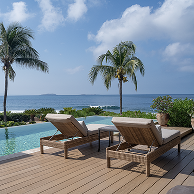 Aereal view of a house with a pool and a beach in the background