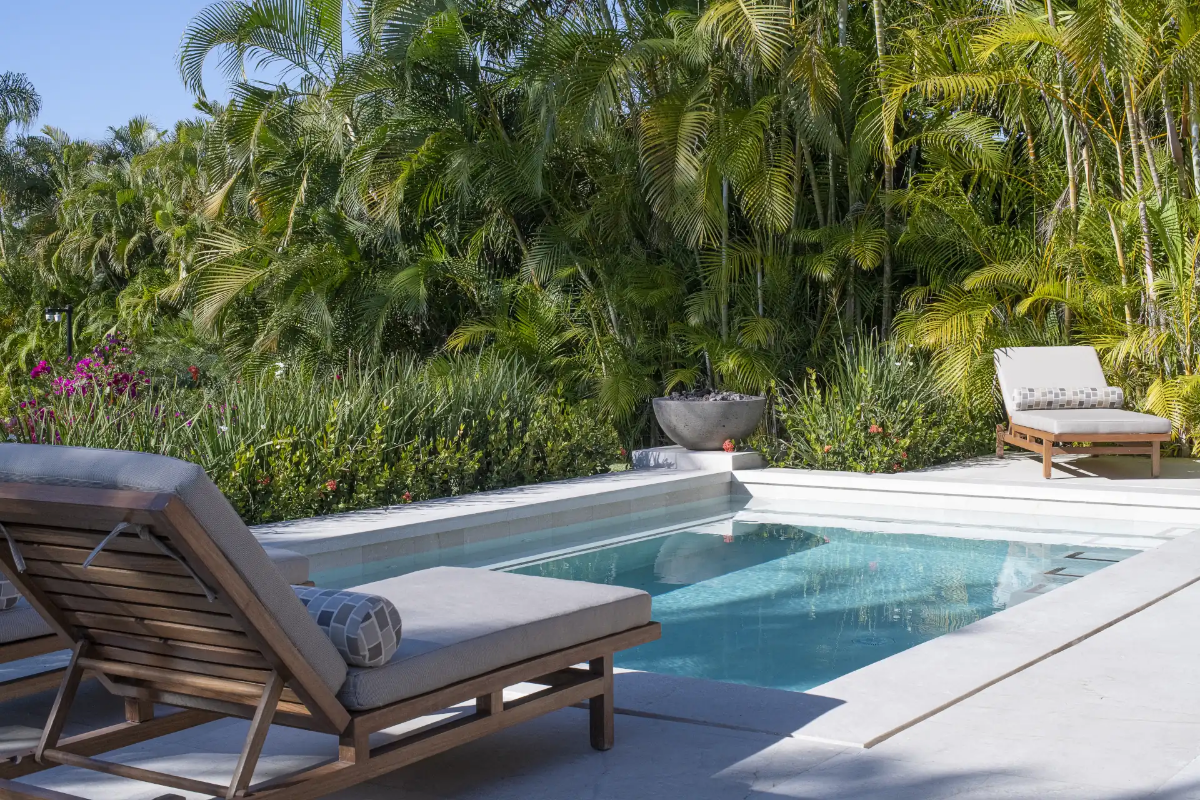 Resort-style pool area nestled among mature palms and lush greenery