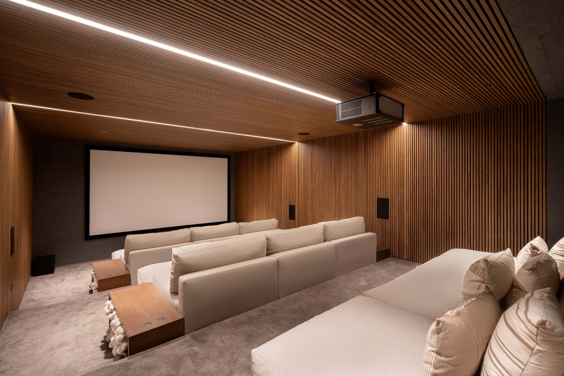 State-of-the-art private home theater at Bella Vils featuring plush tiered seating and wooden acoustic paneling